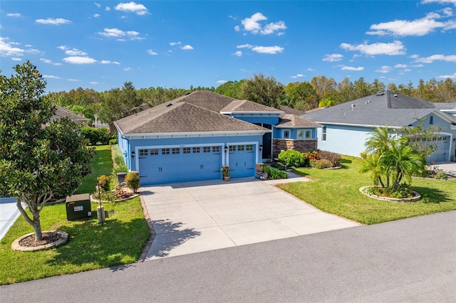 view of front facade with an attached garage, driveway, a front yard, and roof with shingles