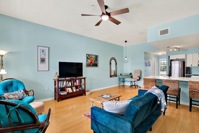 living room with ceiling fan and light hardwood / wood-style floors