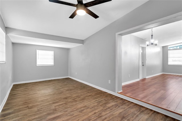 interior space with ceiling fan with notable chandelier and dark hardwood / wood-style floors