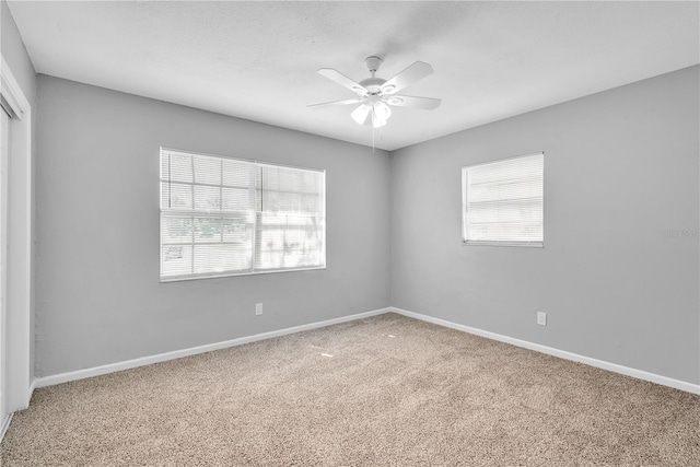 carpeted spare room featuring ceiling fan