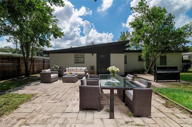 rear view of property featuring an outdoor hangout area and a patio area