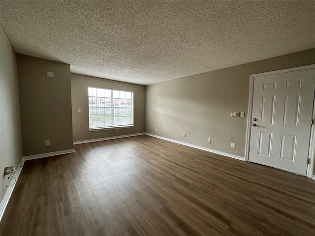 unfurnished room with dark wood-type flooring and a textured ceiling