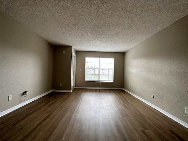 spare room with dark wood-type flooring and a textured ceiling