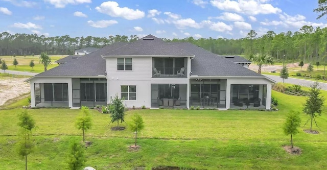 back of property with a sunroom and a yard