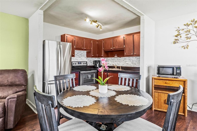 kitchen featuring tasteful backsplash, appliances with stainless steel finishes, sink, and dark hardwood / wood-style floors