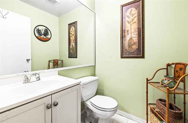 bathroom with toilet, vanity, and tile patterned floors