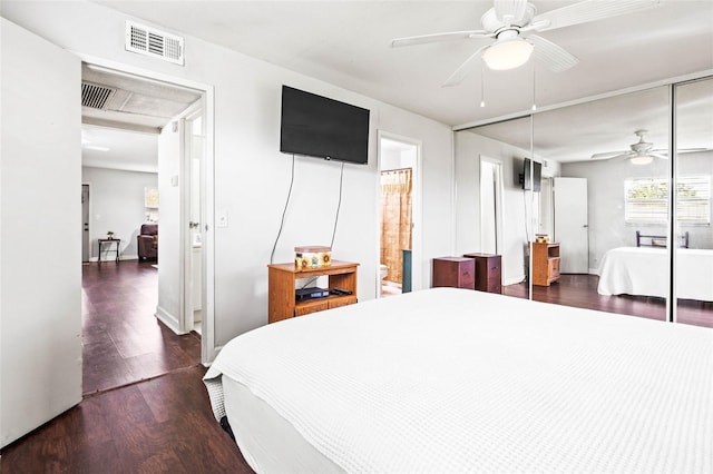 bedroom featuring dark hardwood / wood-style flooring, ensuite bath, a closet, and ceiling fan