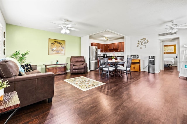 living room with ceiling fan and dark hardwood / wood-style flooring