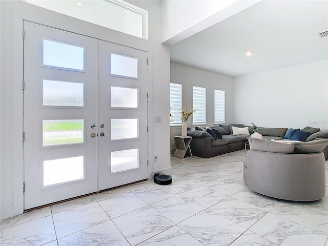 entryway with a towering ceiling and french doors