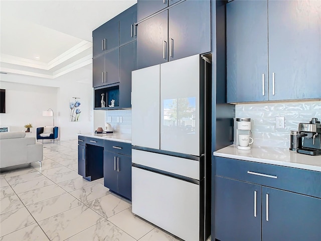 kitchen with white refrigerator, blue cabinets, tasteful backsplash, and crown molding