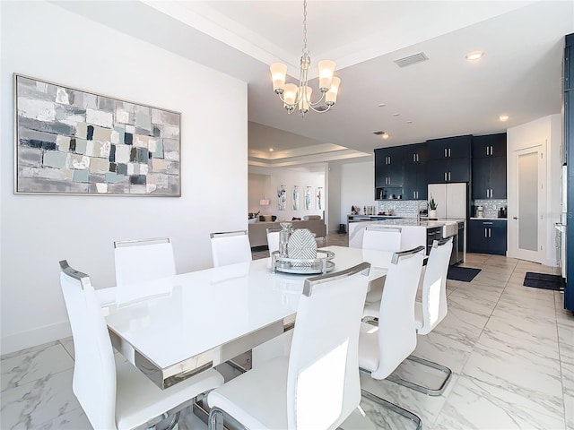 dining room with a raised ceiling and an inviting chandelier