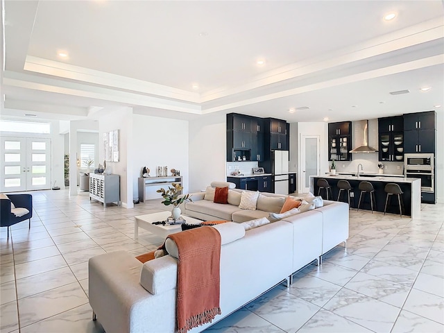 living room with sink and a tray ceiling