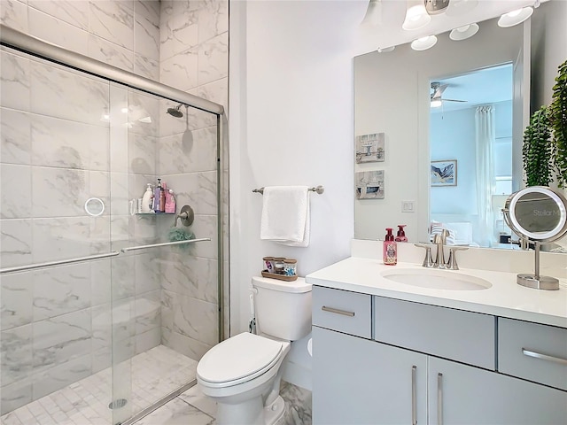 bathroom with ceiling fan, vanity, a shower with shower door, and toilet