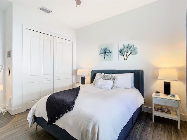 bedroom featuring ceiling fan, dark hardwood / wood-style flooring, and a closet