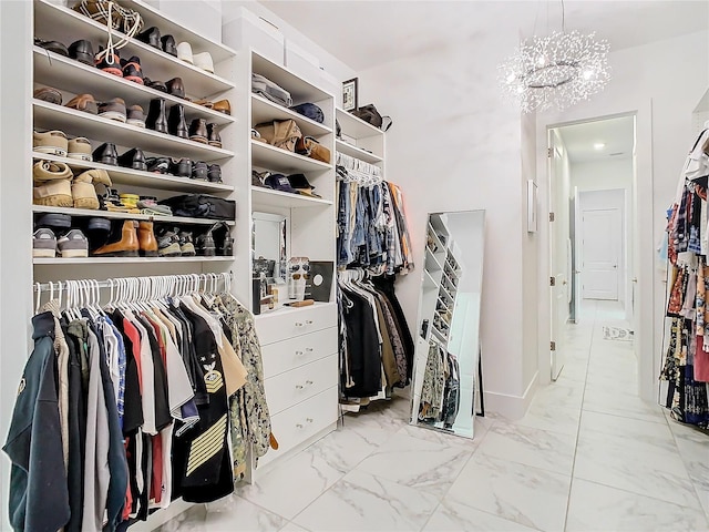 walk in closet with an inviting chandelier