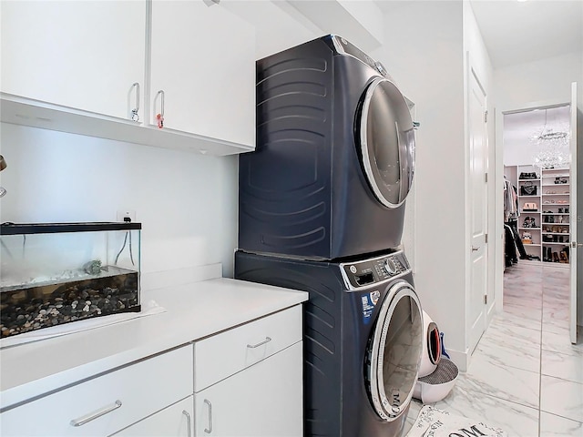 laundry area featuring cabinets and stacked washer / drying machine