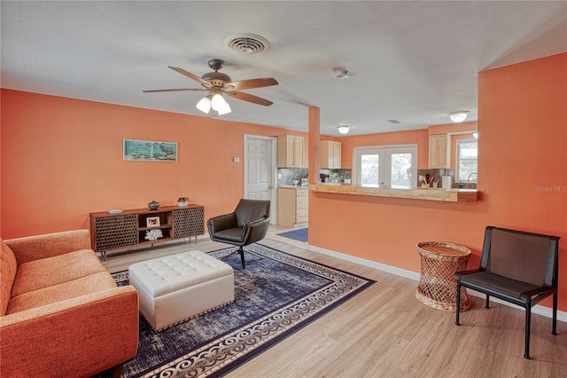 living room with ceiling fan, french doors, and light hardwood / wood-style floors