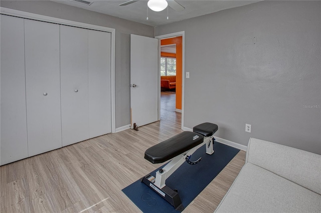 exercise room featuring ceiling fan and light wood-type flooring