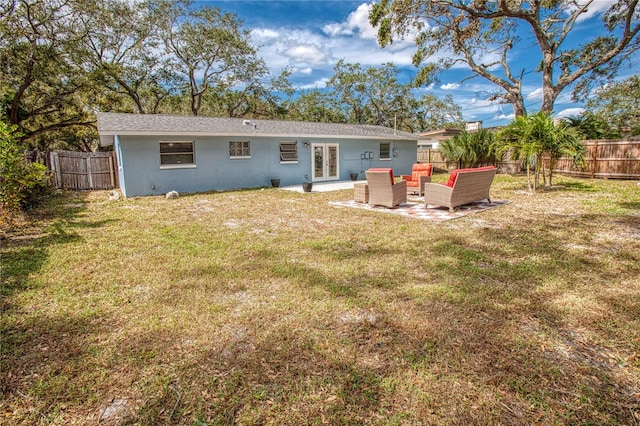 back of property with a yard, outdoor lounge area, and french doors