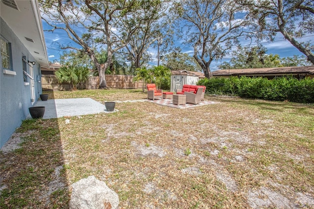 view of yard with an outdoor living space, a patio, and a storage unit