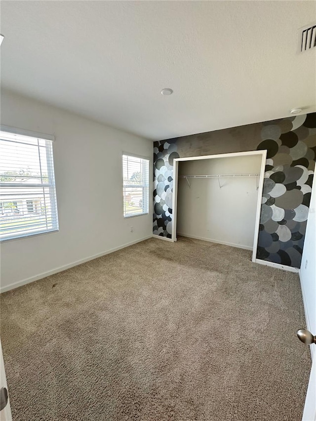 unfurnished bedroom with a closet and carpet floors