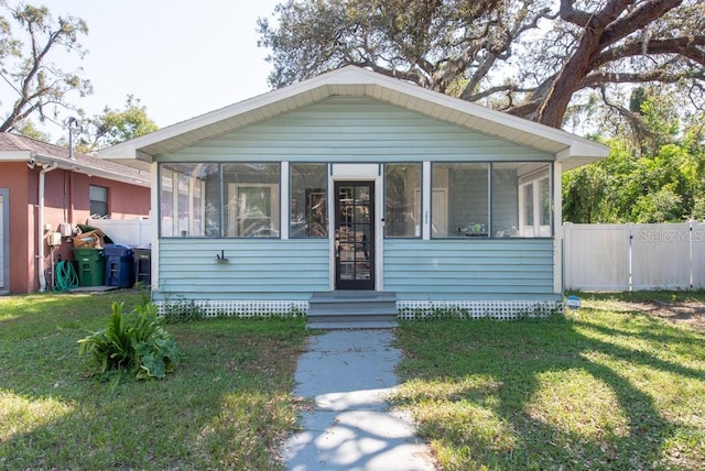 bungalow-style house with a front lawn and a sunroom