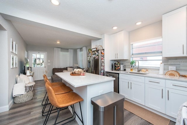 kitchen with white cabinetry, appliances with stainless steel finishes, sink, and decorative backsplash