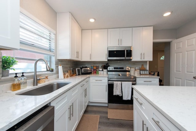 kitchen with sink, white cabinetry, stainless steel appliances, and dark hardwood / wood-style flooring