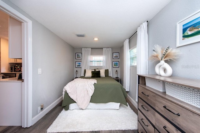 bedroom with dark hardwood / wood-style flooring