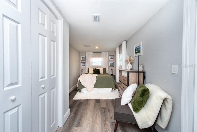 bedroom with wood-type flooring and a closet