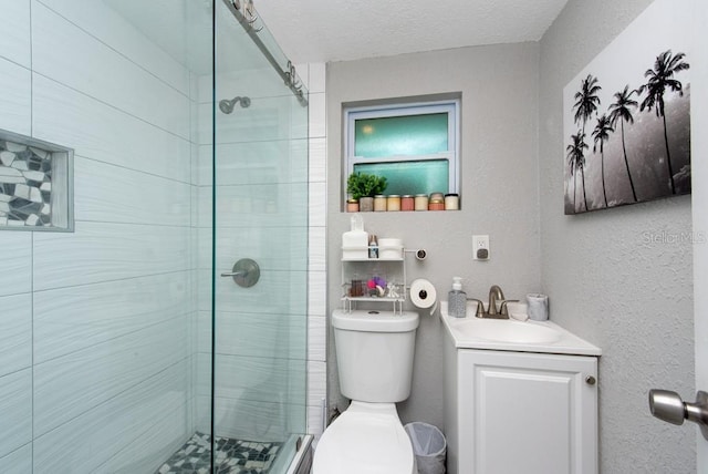 bathroom with vanity, toilet, a textured ceiling, and a shower with shower door