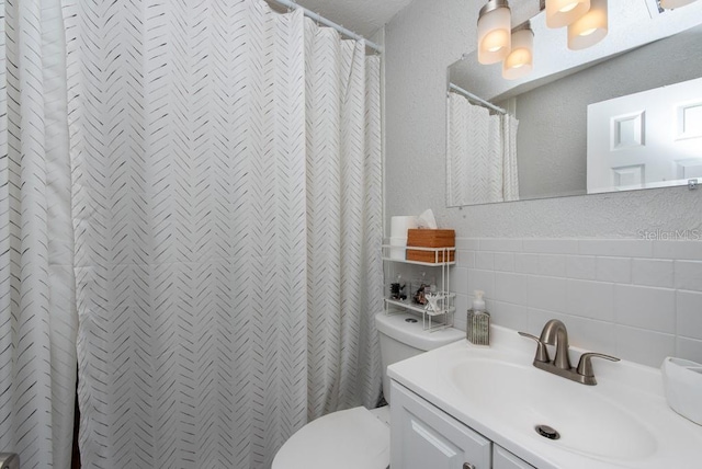 bathroom featuring toilet, tile walls, a shower with curtain, vanity, and decorative backsplash