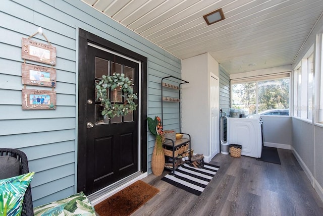 entrance to property featuring covered porch and washer and clothes dryer