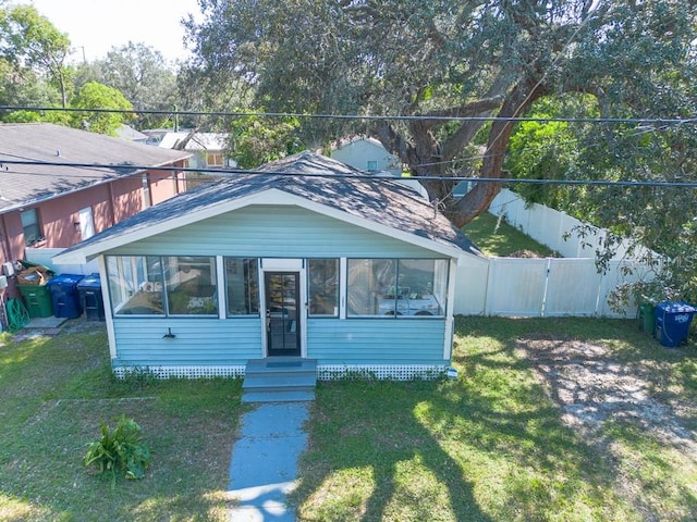 view of front of property featuring a sunroom and a front yard