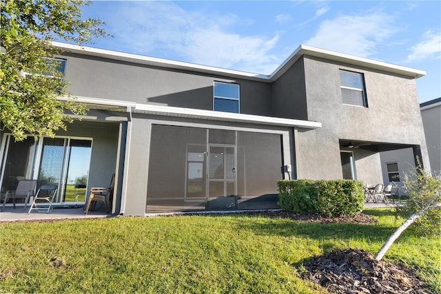 back of property with a patio area and a lawn