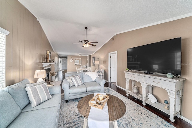 living room with wood walls, ceiling fan, vaulted ceiling, hardwood / wood-style flooring, and ornamental molding