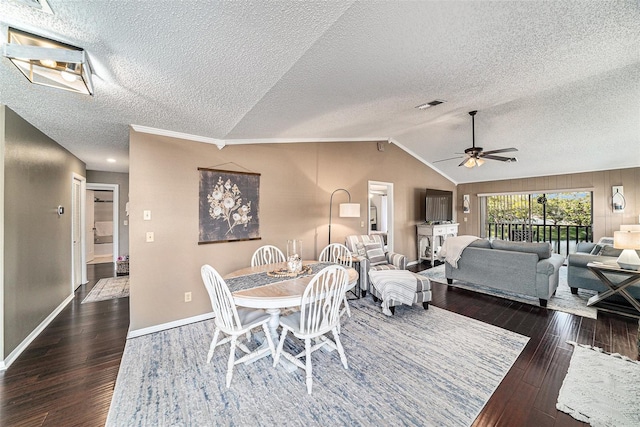 dining space with ceiling fan, a textured ceiling, vaulted ceiling, and dark hardwood / wood-style floors