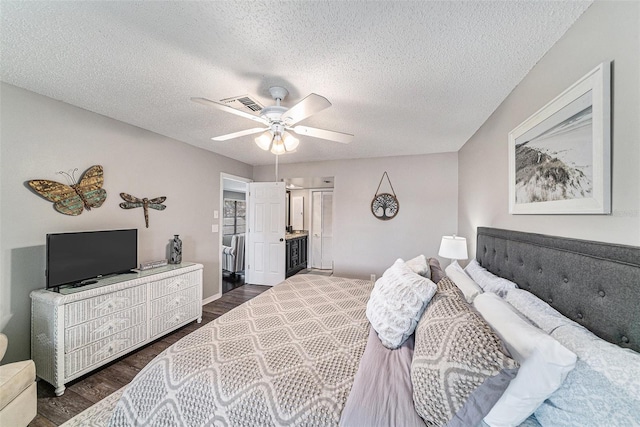 bedroom with connected bathroom, ceiling fan, dark wood-type flooring, and a textured ceiling