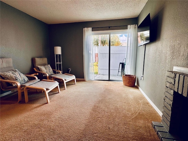 living area with a textured ceiling, carpet, and a brick fireplace