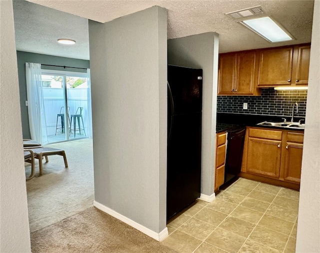 kitchen with sink, black appliances, light colored carpet, a textured ceiling, and tasteful backsplash