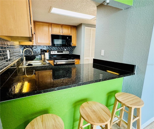 kitchen with tasteful backsplash, stainless steel electric range, sink, and a breakfast bar area