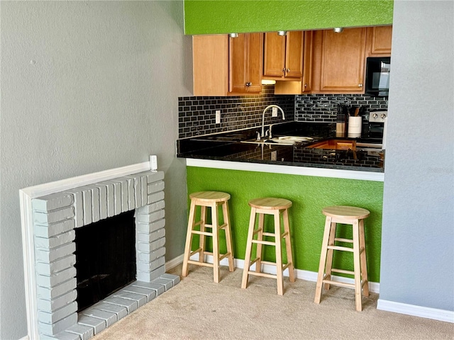 kitchen featuring tasteful backsplash, a kitchen bar, light colored carpet, and white range oven