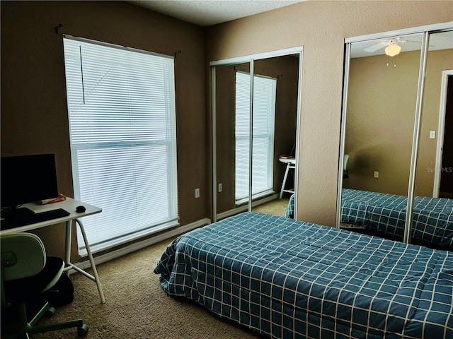 bedroom featuring multiple closets and carpet