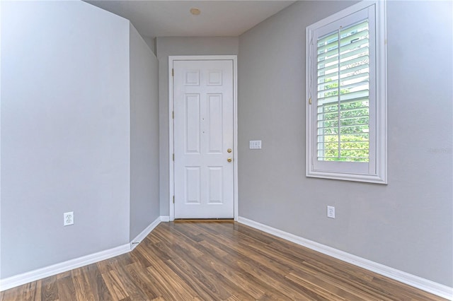 unfurnished room with dark wood-type flooring