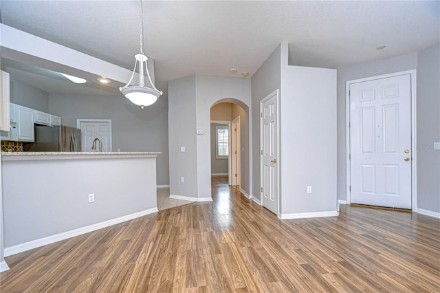 interior space with a textured ceiling, sink, and dark wood-type flooring