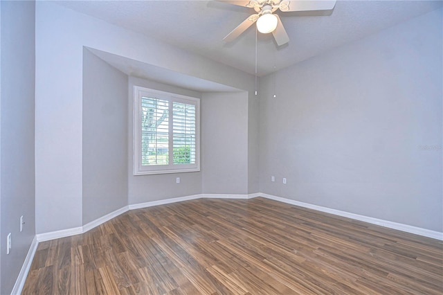 empty room featuring ceiling fan and dark hardwood / wood-style flooring