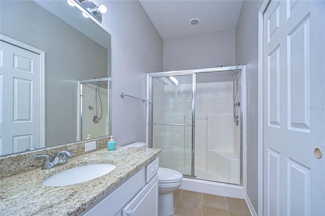 bathroom featuring toilet, an enclosed shower, vanity, and tile patterned floors