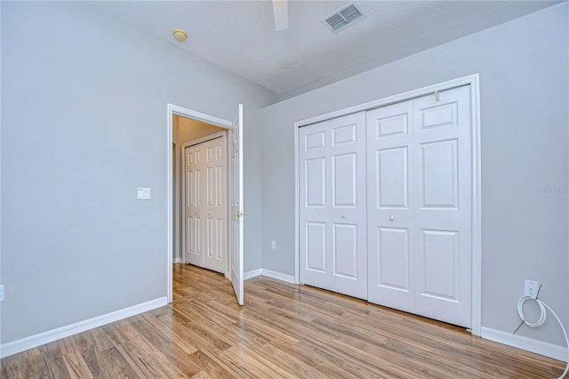 unfurnished bedroom with a closet, light wood-type flooring, and ceiling fan