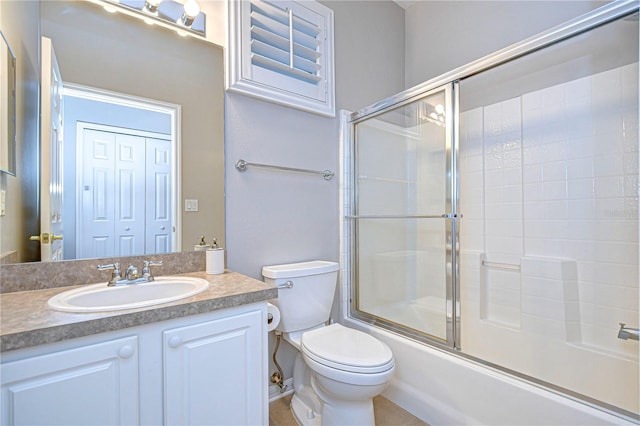 full bathroom featuring toilet, combined bath / shower with glass door, vanity, and tile patterned flooring