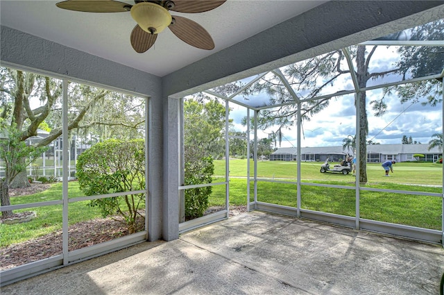 unfurnished sunroom with ceiling fan